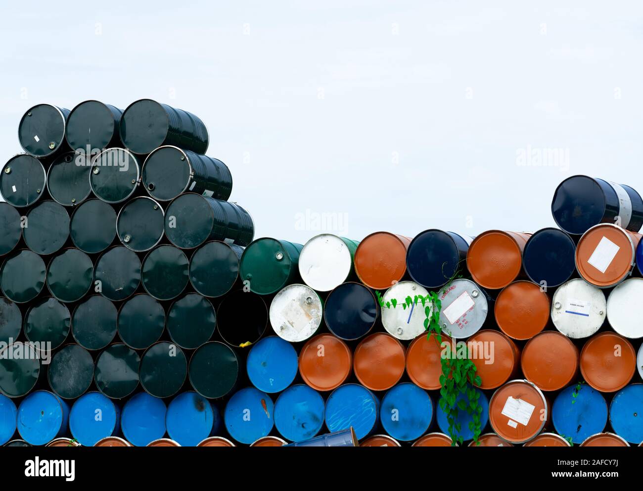 Old chemical barrels. Blue, orange, and black oil drum. Steel oil tank