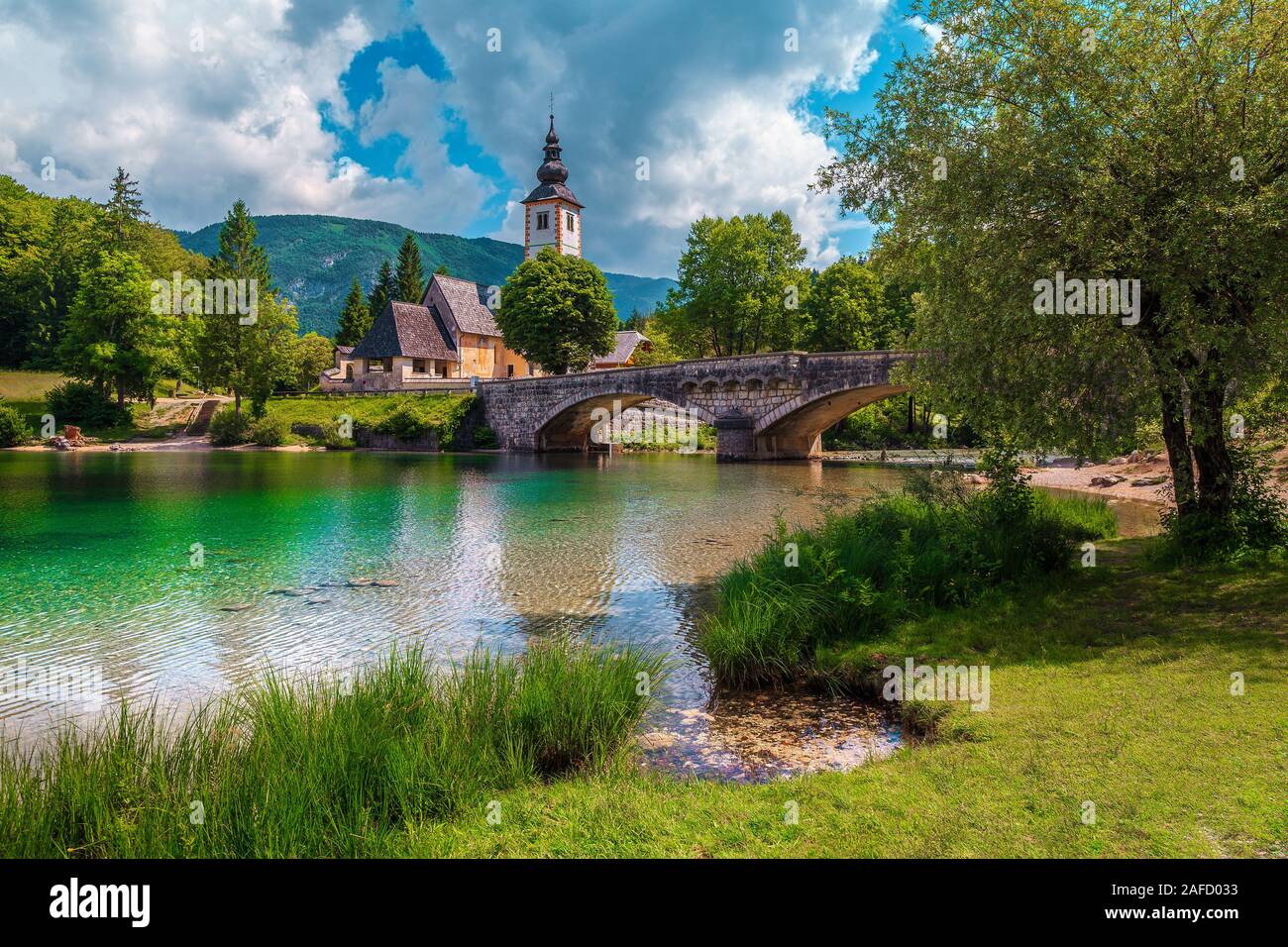 Popular travel and recreation location with traditional church and alpine turquoise Bohinj lake, Slovenia, Europe Stock Photo