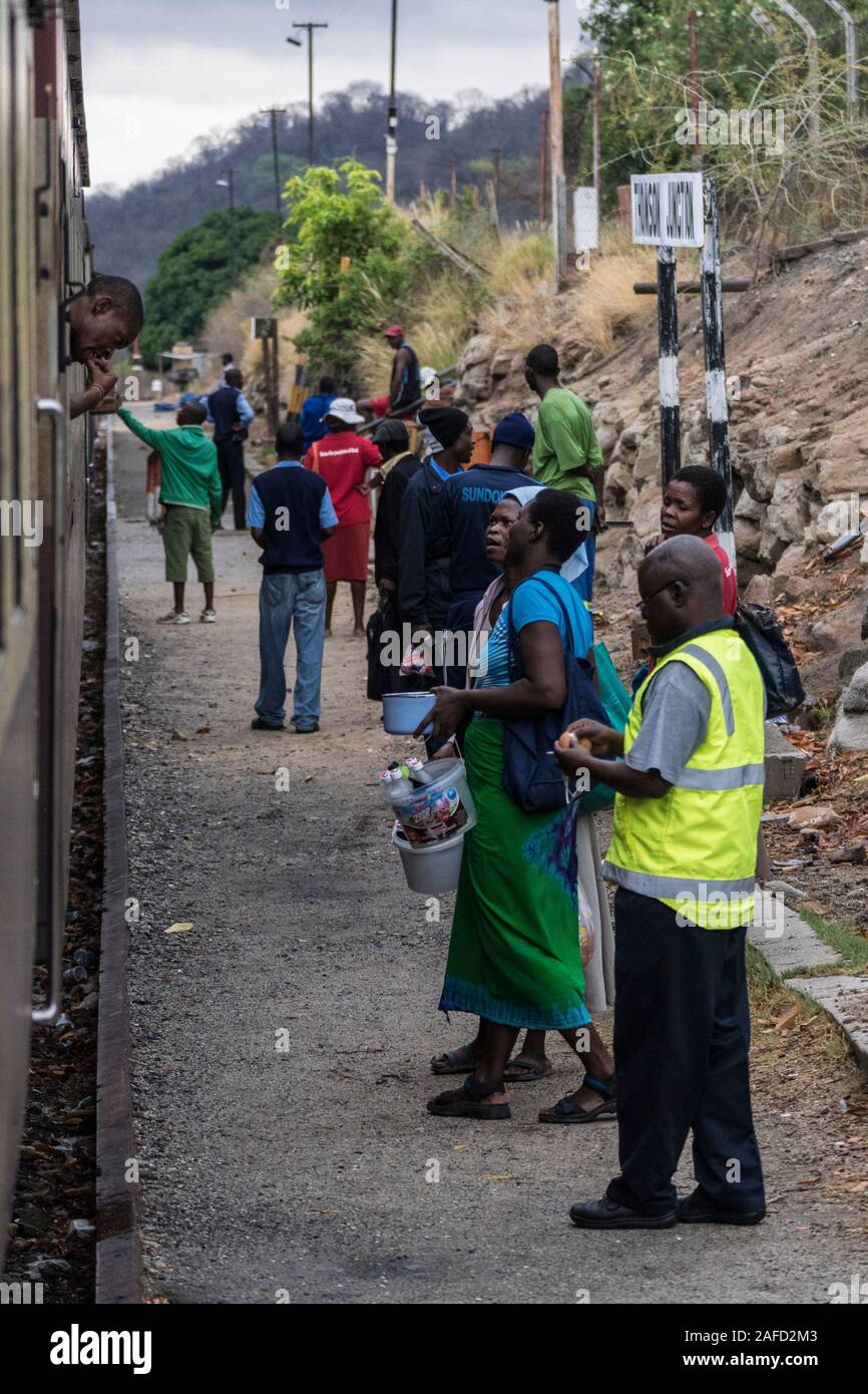 Zimbabwe. Villagers wait at a local station and sell fruit to the