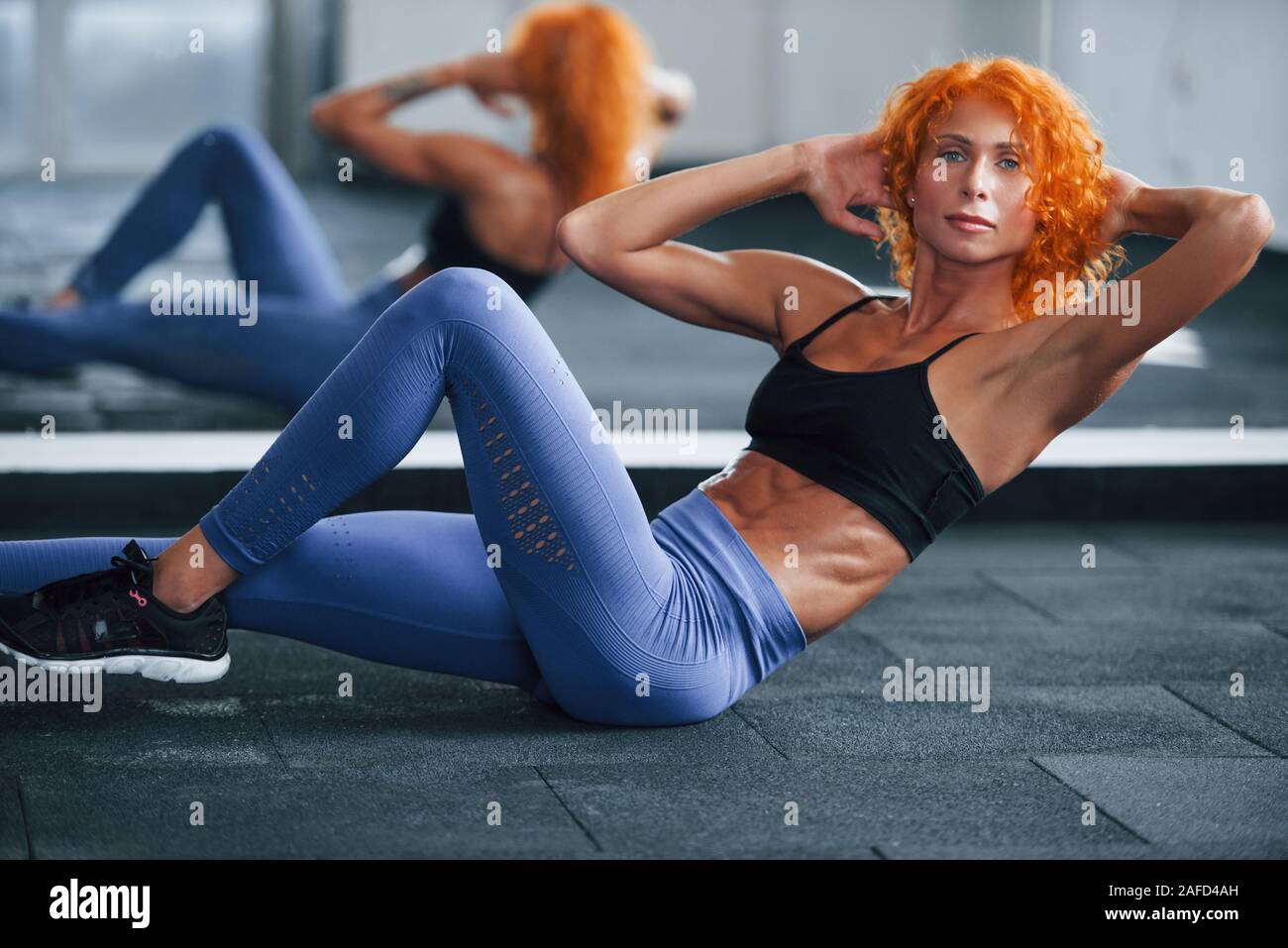 Doing Abs Sporty Redhead Girl Have Fitness Day In Gym At Daytime Muscular Body Type Stock