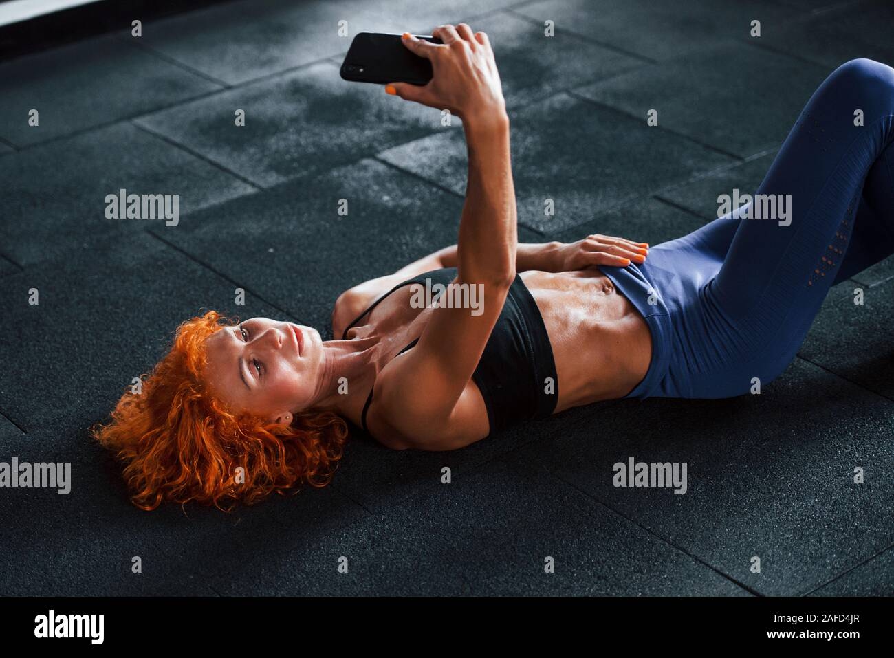 Taking a selfie with phone. Sporty redhead girl have fitness day