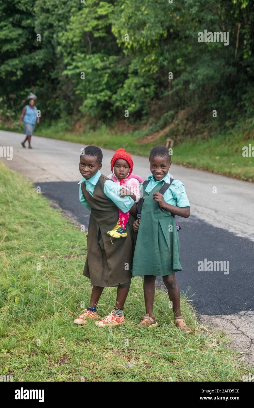 Zimbabwe, A rural area in the eastern highlands. A young girl, with a short  haircut to aid in preventing louses, carries her young sister on her back  Stock Photo - Alamy