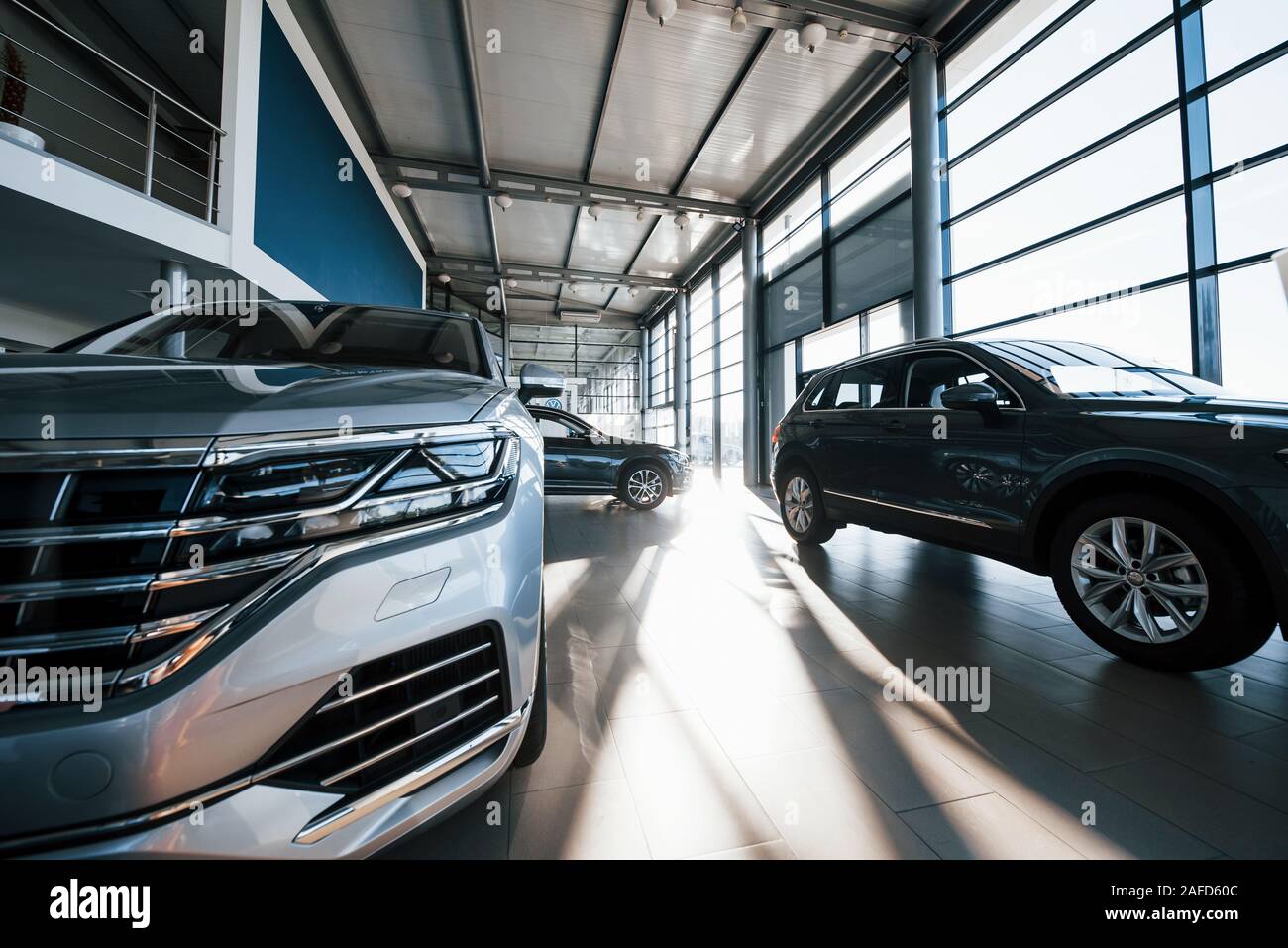 Brand new cars at dealer showroom. Perfectly polished. Natural lighting