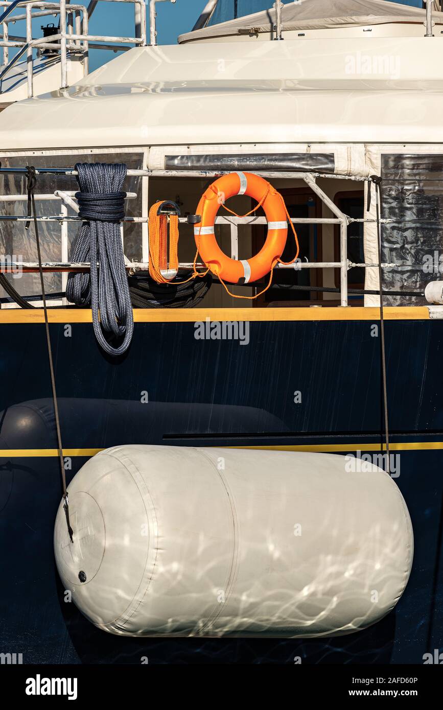Closeup of a large white boat fender protecting the side of a yacht
