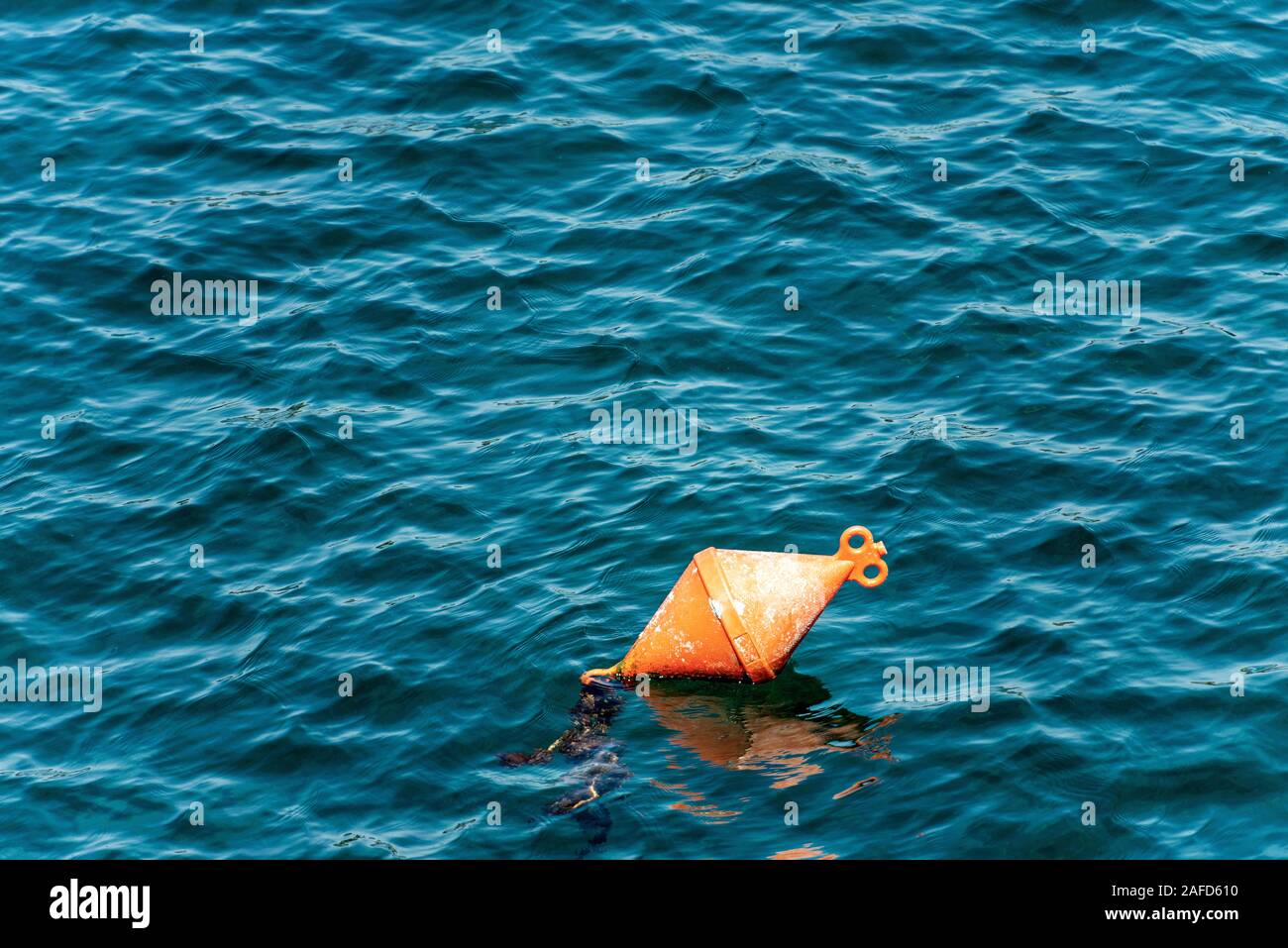 One orange mooring buoy on the surface of the water. Mediterranean sea