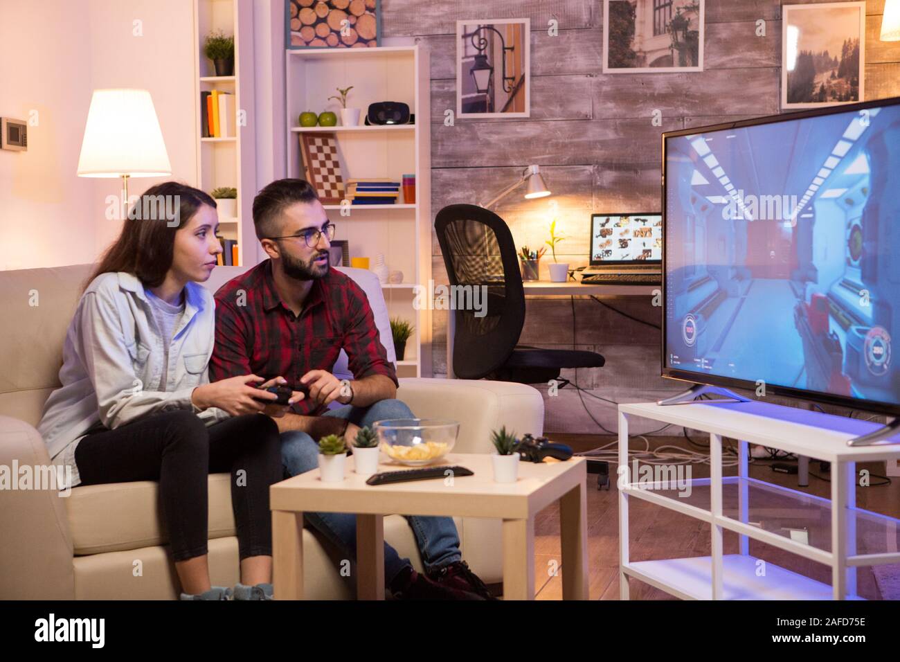 Boyfriend learning his girlfriend to play video games on