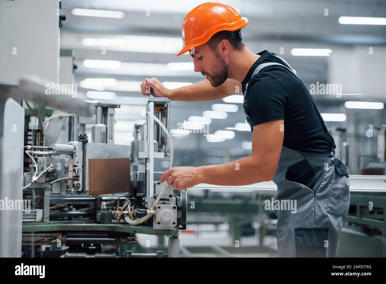 Operator of machine. Industrial worker indoors in factory. Young ...