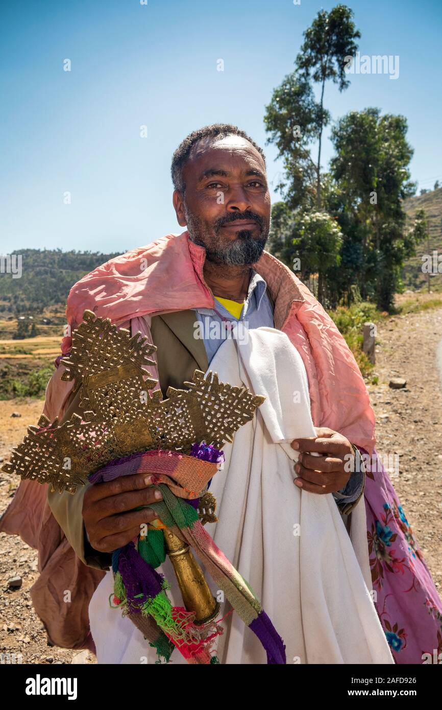 Ethiopia, Tigray, Adigrat, priest soliciting donations at roadside, holding large traditional bronze cross Stock Photo