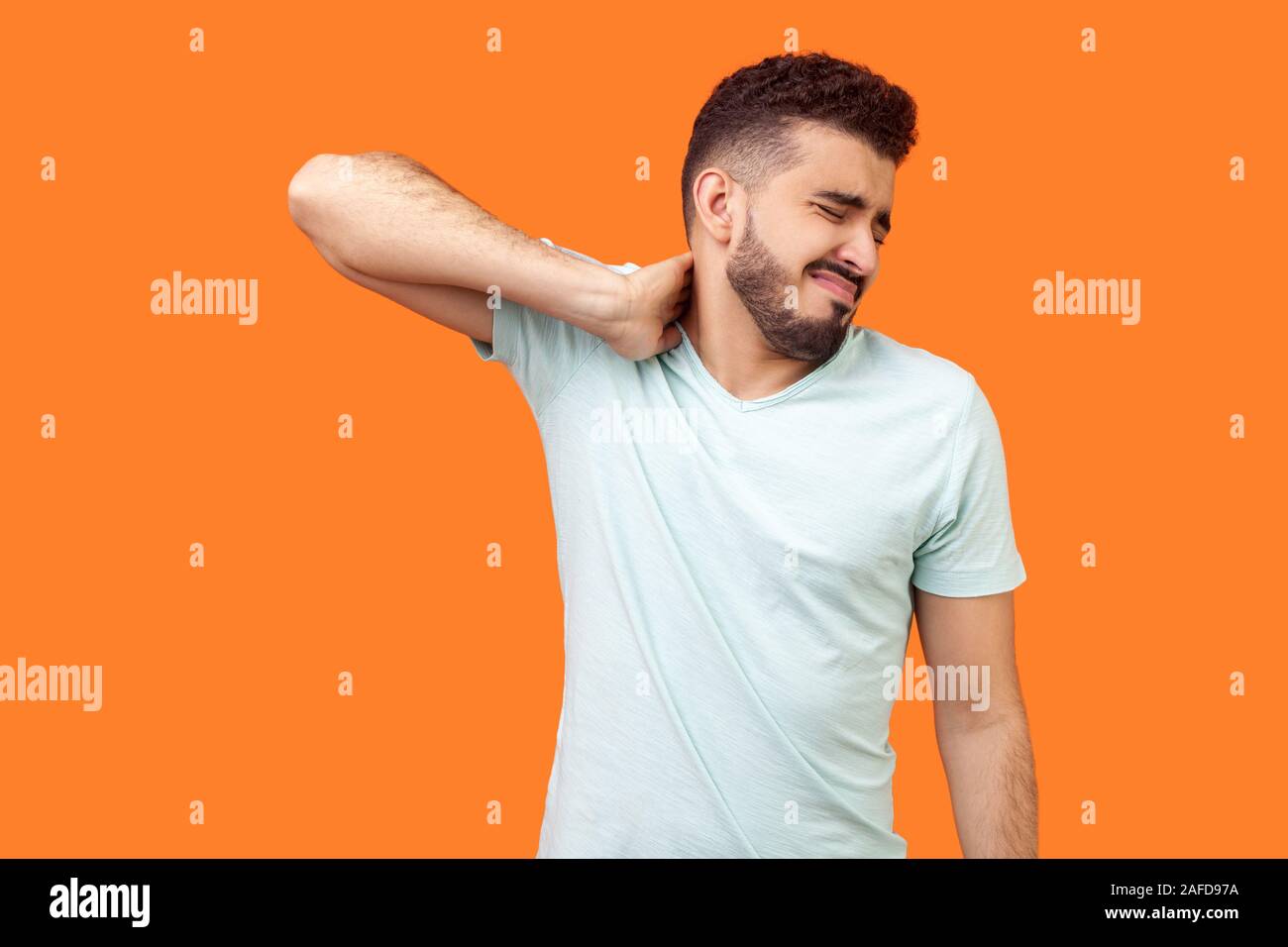 Portrait of exhausted man with beard in white tshirt rubbing