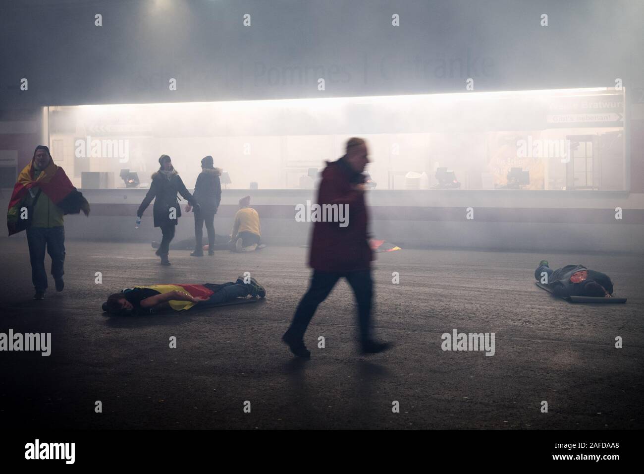 Munich, Germany. 15th Dec, 2019. Stadium visitors played by extras run in confusion after a simulated explosion during a disaster control exercise for the European Football Championship 2020 in the Allianz Arena. During the exercise, the explosion of a deep fryer in a snack bar inside the arena was simulated with a mass attack of injured persons. The joint disaster control exercise 'EMÜ19' of fire brigade, police, rescue services, the City of Munich and the German Football Association serves to prepare for the UEFA European Championship 2020. Credit: Matthias Balk/dpa/Alamy Live News Stock Photo