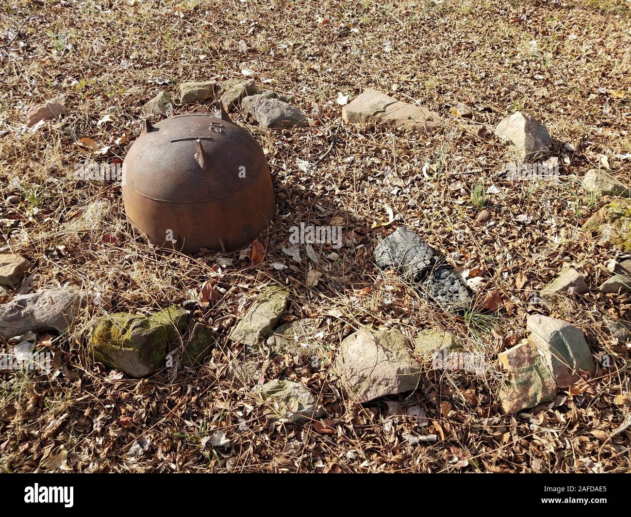 metal cauldron and burned wood with rocks in fire pit Stock Photo Alamy