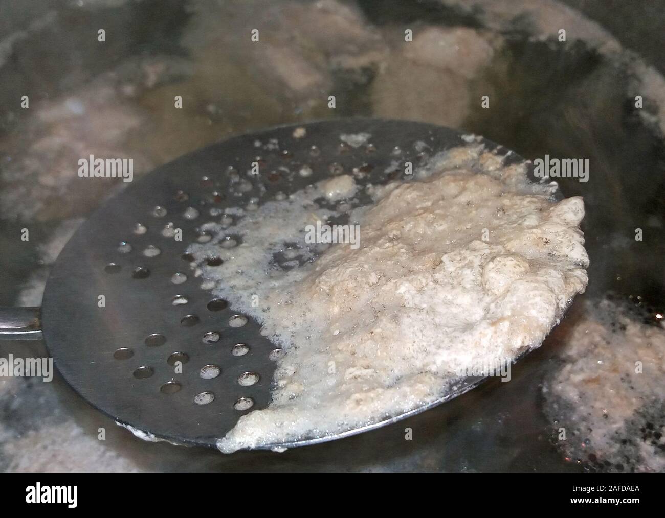 Remove the foam from boiling meat Stock Photo Alamy