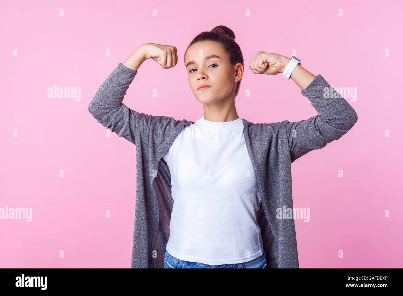 Portrait of self-confident teenage girl with bun hairstyle in casual  clothes raising hands showing power, feeling independent strong with proud  look Stock Photo - Alamy