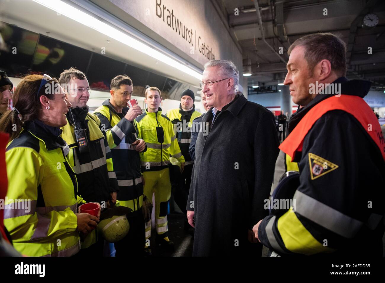 Munich, Germany. 15th Dec, 2019. Joachim Herrmann (CSU, 2nd from right), Minister of the Interior of Bavaria, thanks the fire brigade after a disaster control exercise for the European Football Championship 2020 in the Allianz Arena. During the exercise, the explosion of a deep fryer in a snack bar inside the arena was simulated with a mass attack of injured persons. The joint disaster control exercise 'EMÜ19' of fire brigade, police, rescue services, the City of Munich and the German Football Association serves to prepare for the UEFA European Championship 2020. Photo: Matthias Balk/dpa Stock Photo