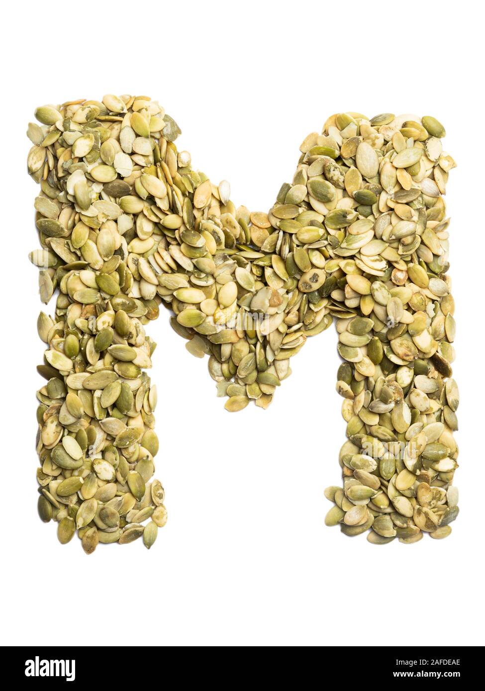 Letter M of the English alphabet from pumpkin seeds on a white isolated ...