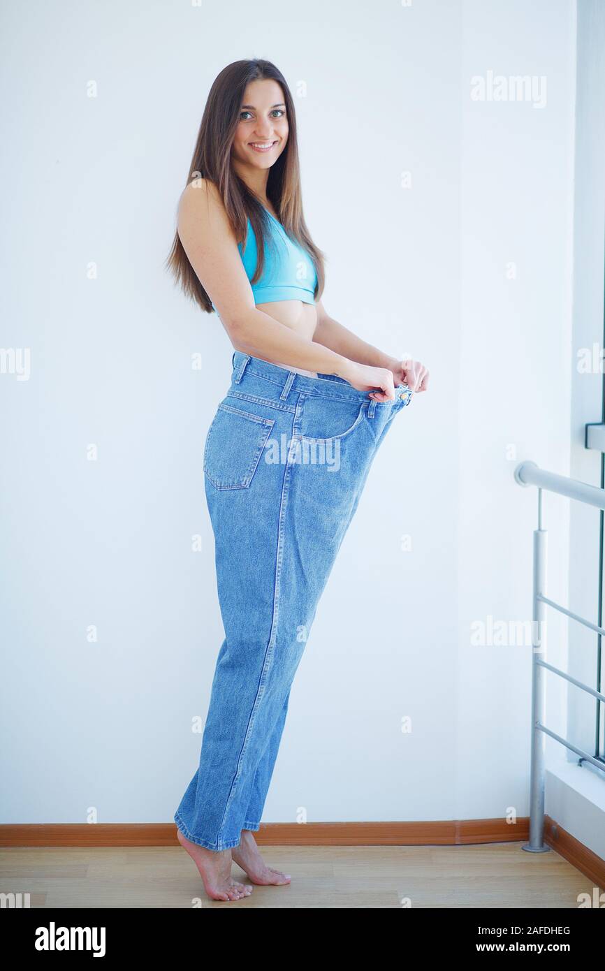 Healthy lifestyle. Beautiful joyful slim girl showing result of diet ...