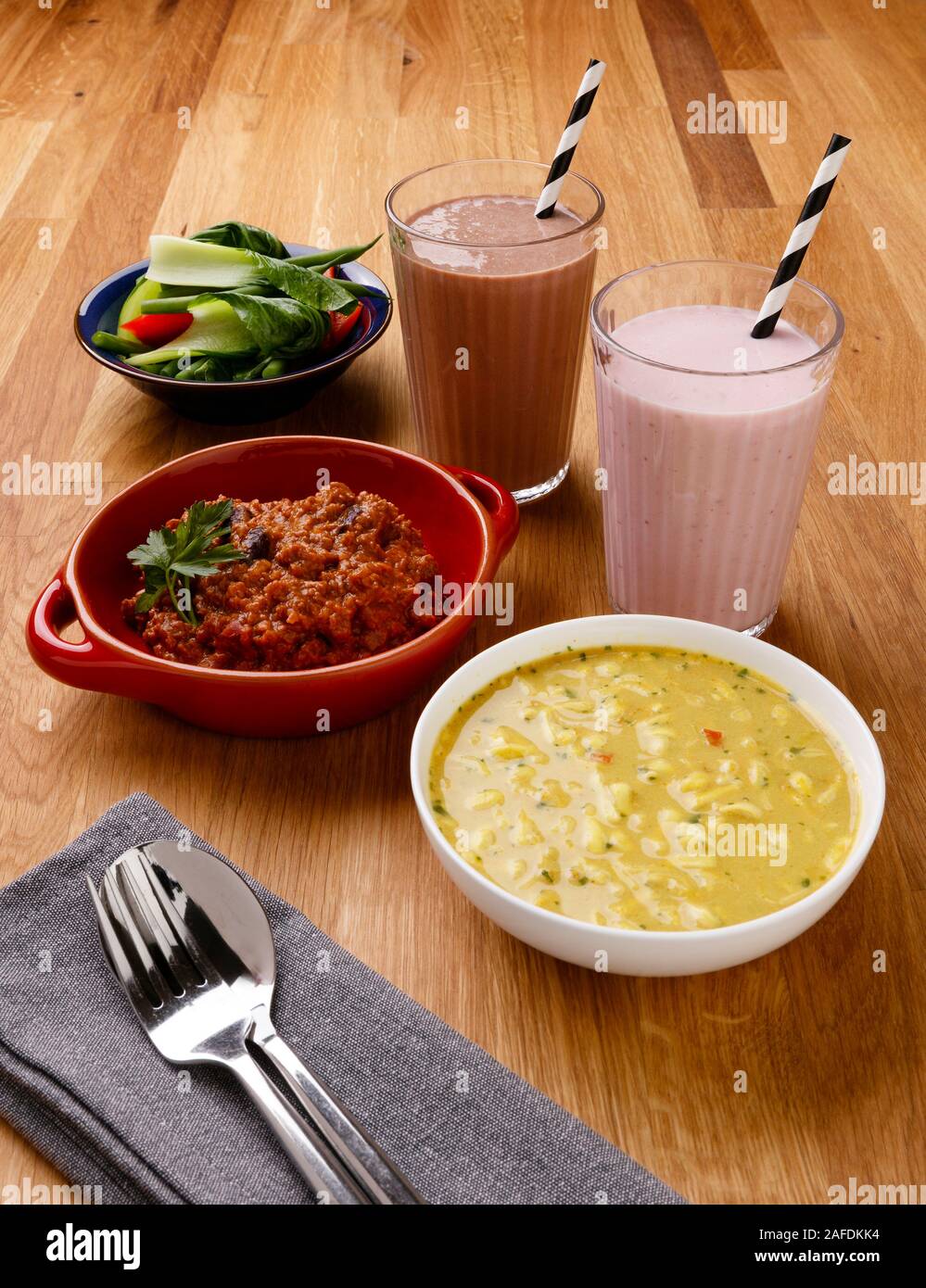 Calorie controlled daily meal plan, including breakfast, lunch and evening meal, with milkshake, shot on a wooden background Stock Photo