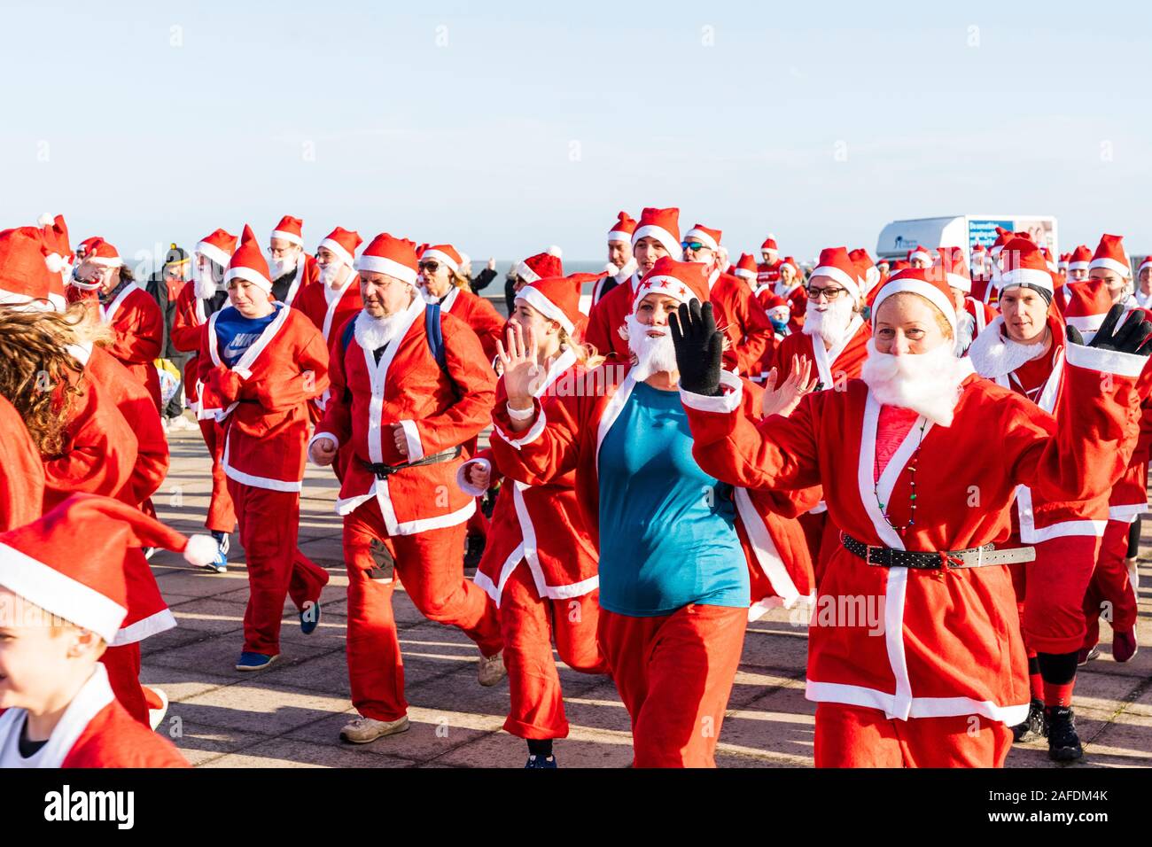Large group of people all dressed up as Father Xmas, gathered on