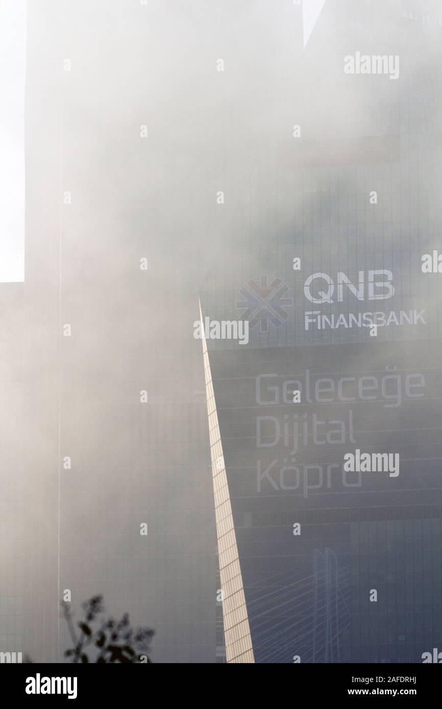 Close up of QNB Finansbank headquarters building at Levent, Istanbul, in a foggy morning with logo, text, name, and some advertisement on the exterior. Stock Photo
