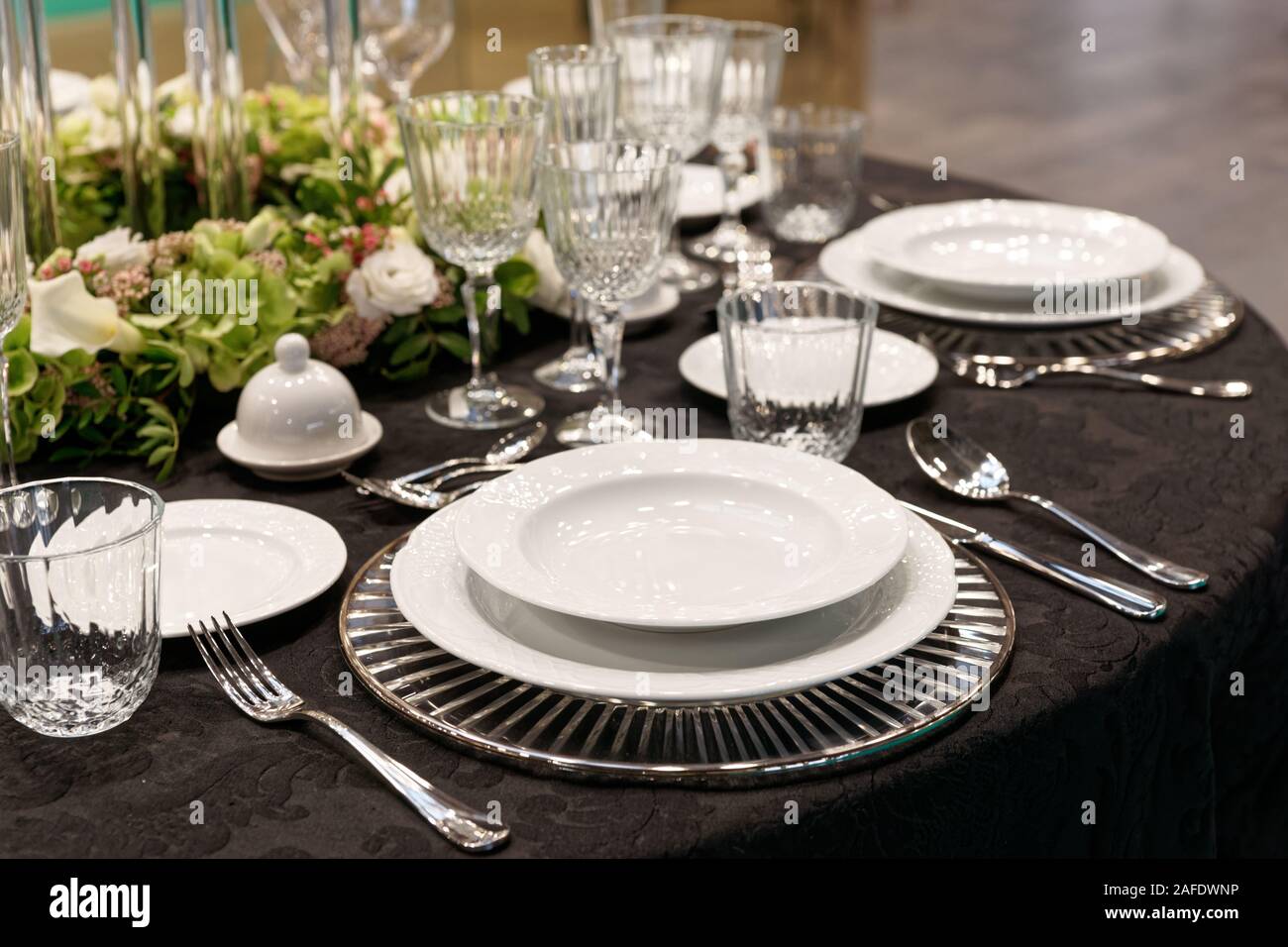 Expensive stylish set of porcelain, cutlery and glassware, place ...