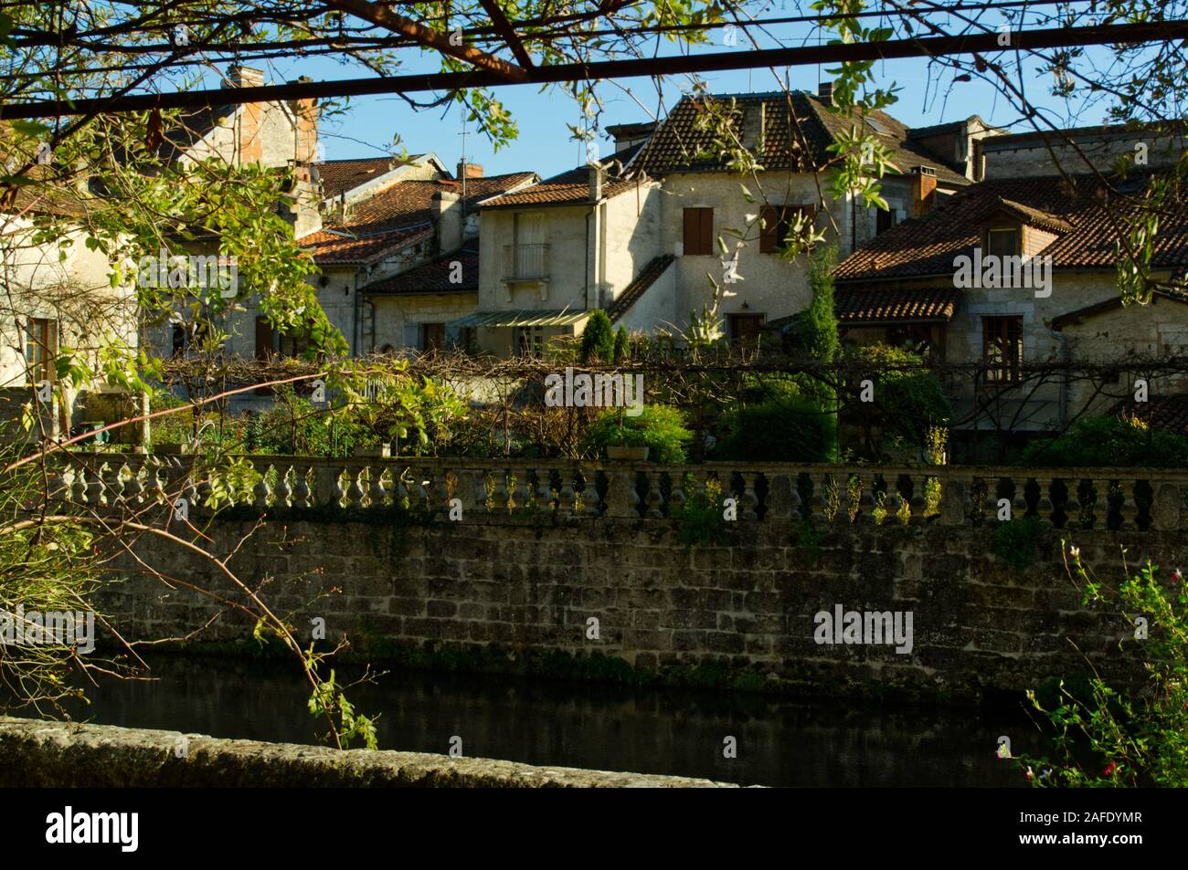Houses backing on to the River Dronne at Brantôme in the autumn sun. Stock Photo