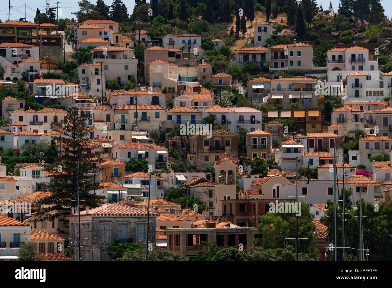 View to white houses with red roofs of Poros town, Saronic islands, Poros island, Greece. Pattern Stock Photo