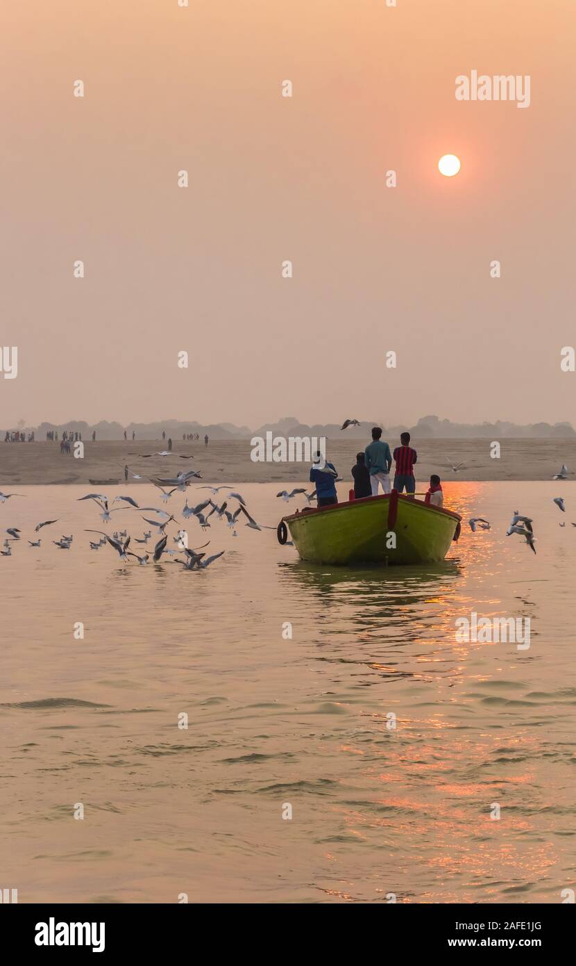 Sunrise over a small boat on the Ganges river in Varanasi, India Stock Photo