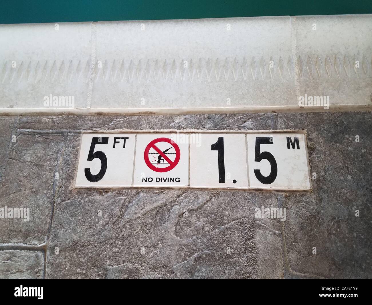no diving warning sign or symbol at edge of swimming pool Stock Photo