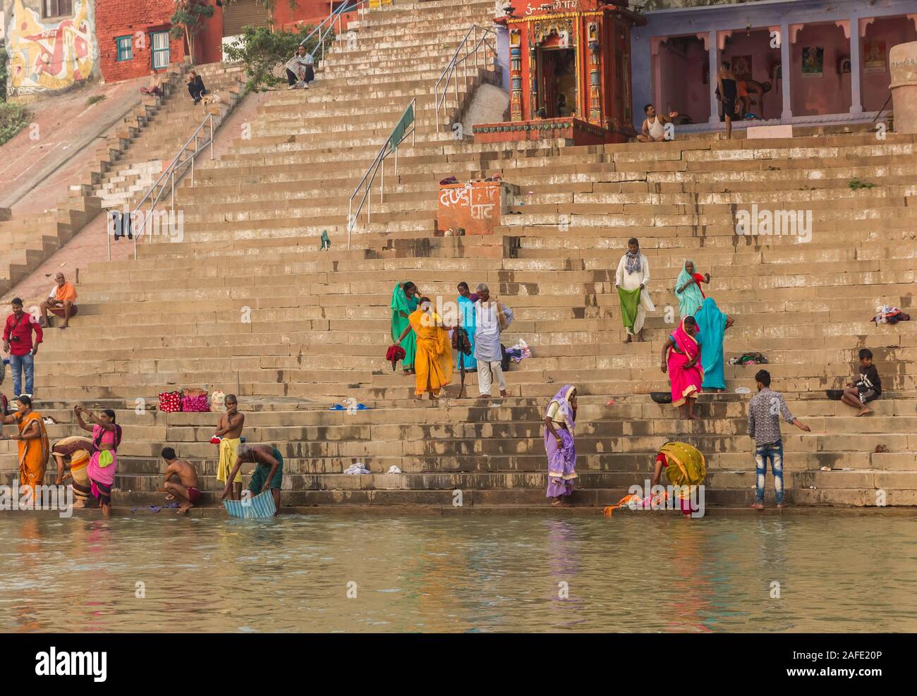 Colorful people at the stairs to the Ganges river in Varanasi, India Stock Photo