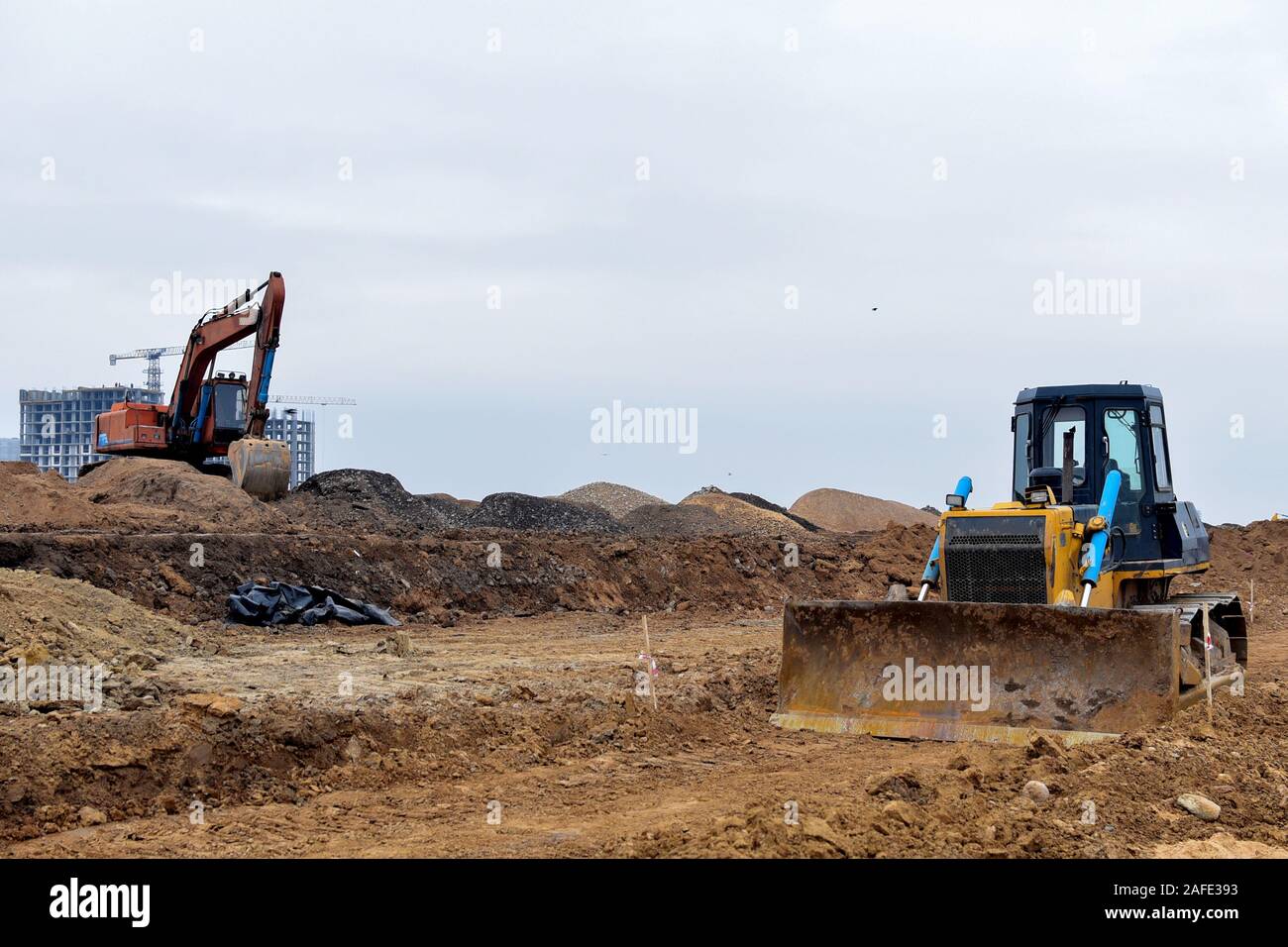 Excavator and a bulldozer work at a construction site. Land clearing