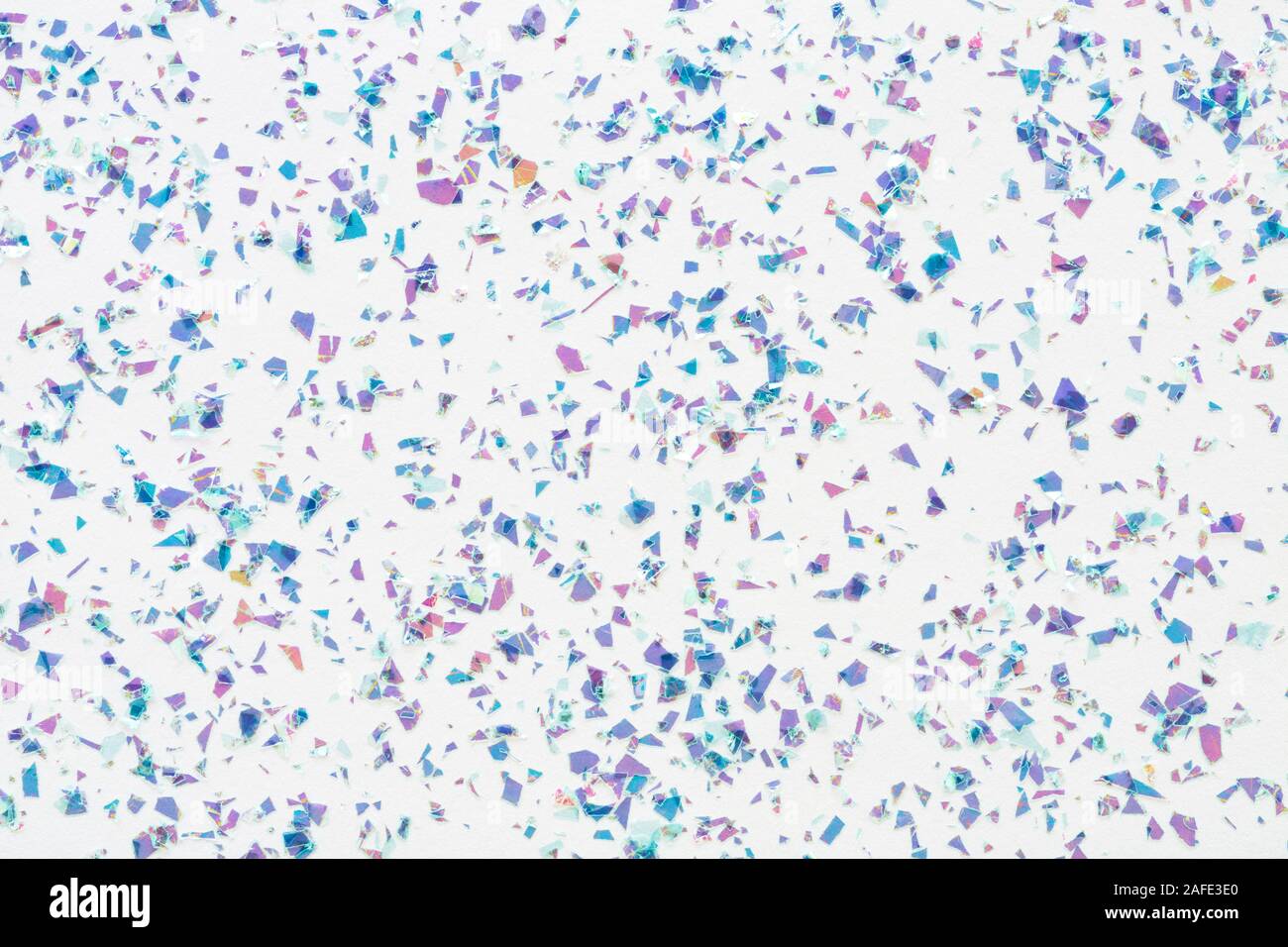 Glowing mica glitter confetti on white background. Festive abstract backdrop. Holiday Flat lay. Stock Photo