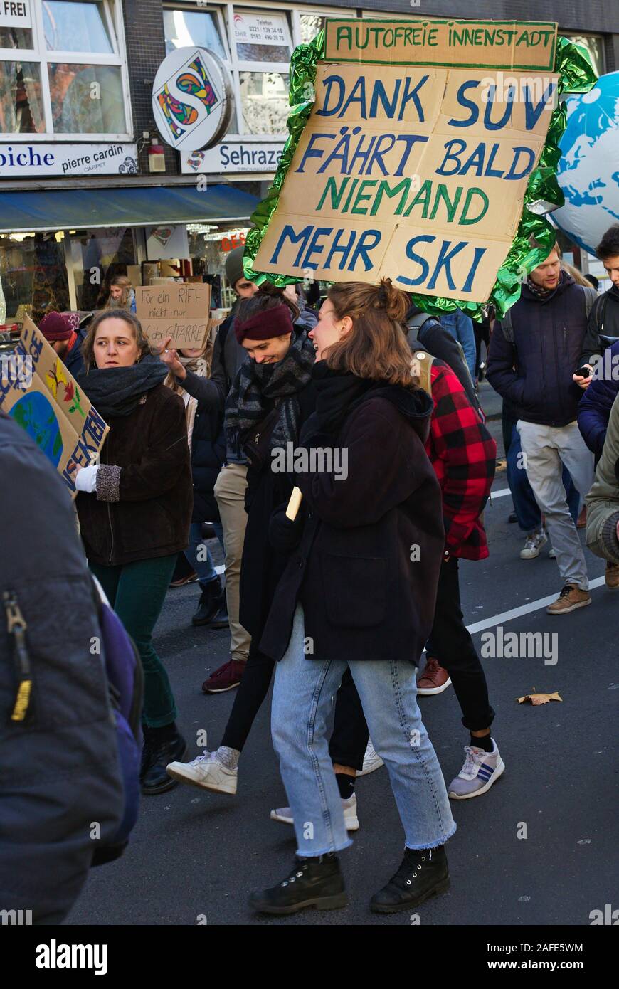 Real People carrying climate protest signs on Fridays for Future demonstration. 'Dank SUV fährt bald niemand mehr Ski' Stock Photo