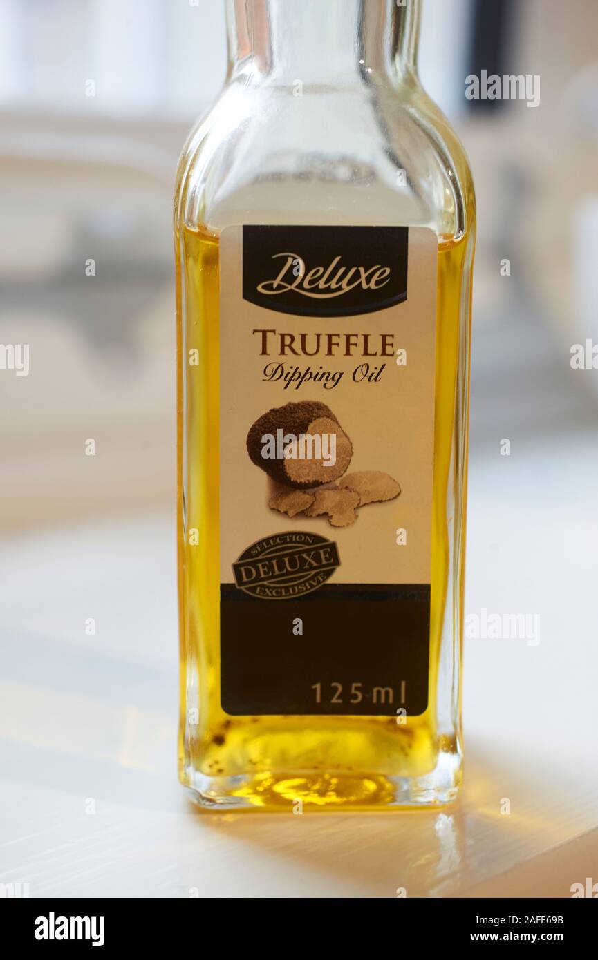 Périgord black truffle Oil in a glass bottle on a white worktop in the kitchen. Stock Photo