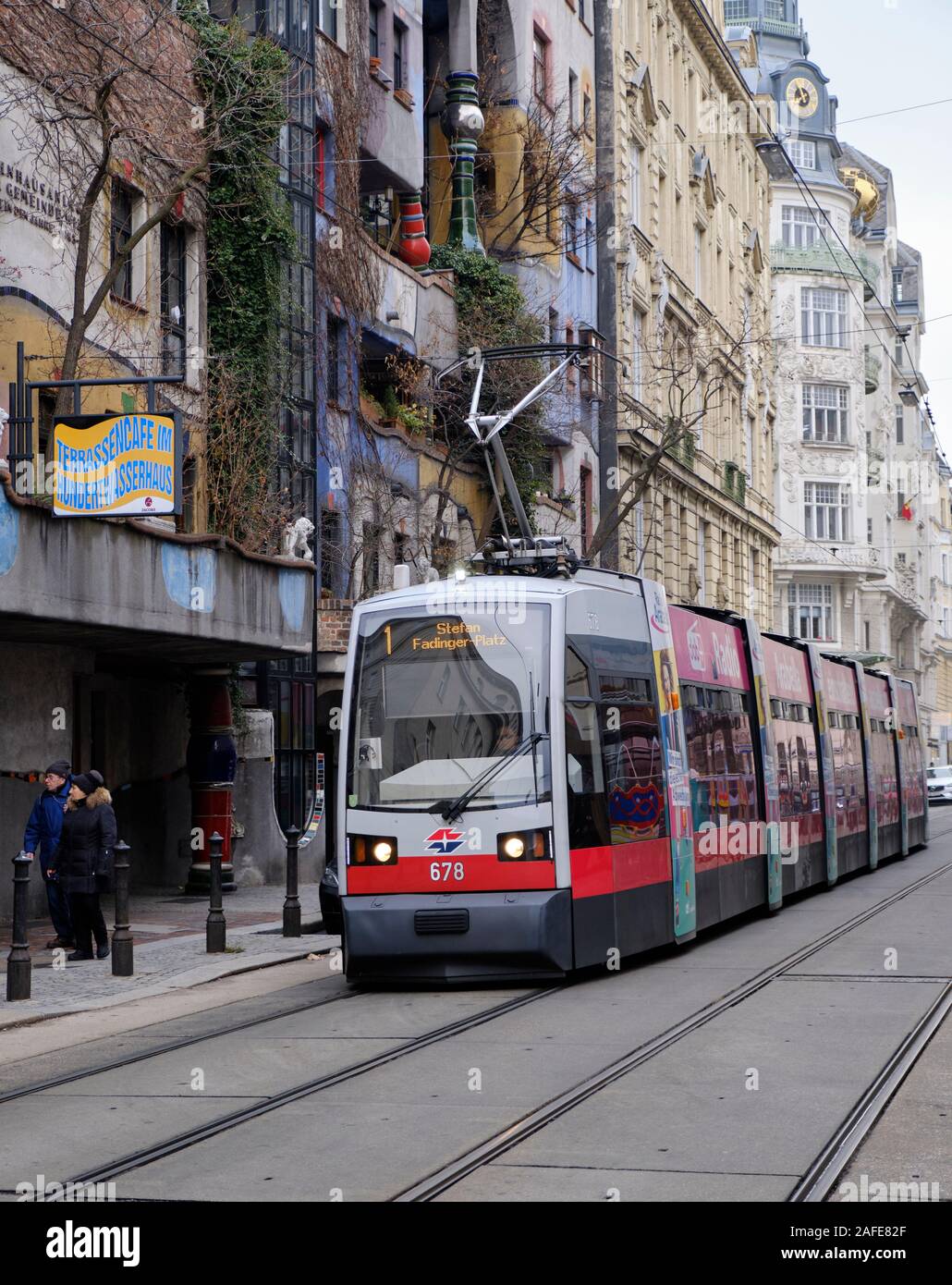 ULF type Vienna Tram riding on tracks in city neighbourhood passing an Hundertwasser designed building Stock Photo