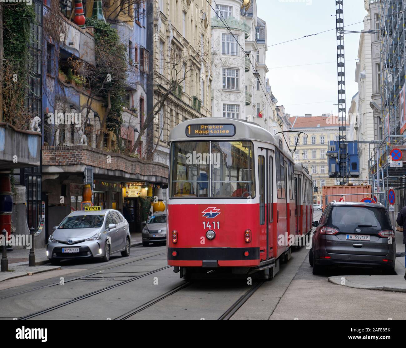 E2 type Vienna Tram riding on tracks in city neighbourhood passing an Hundertwasser designed building Stock Photo