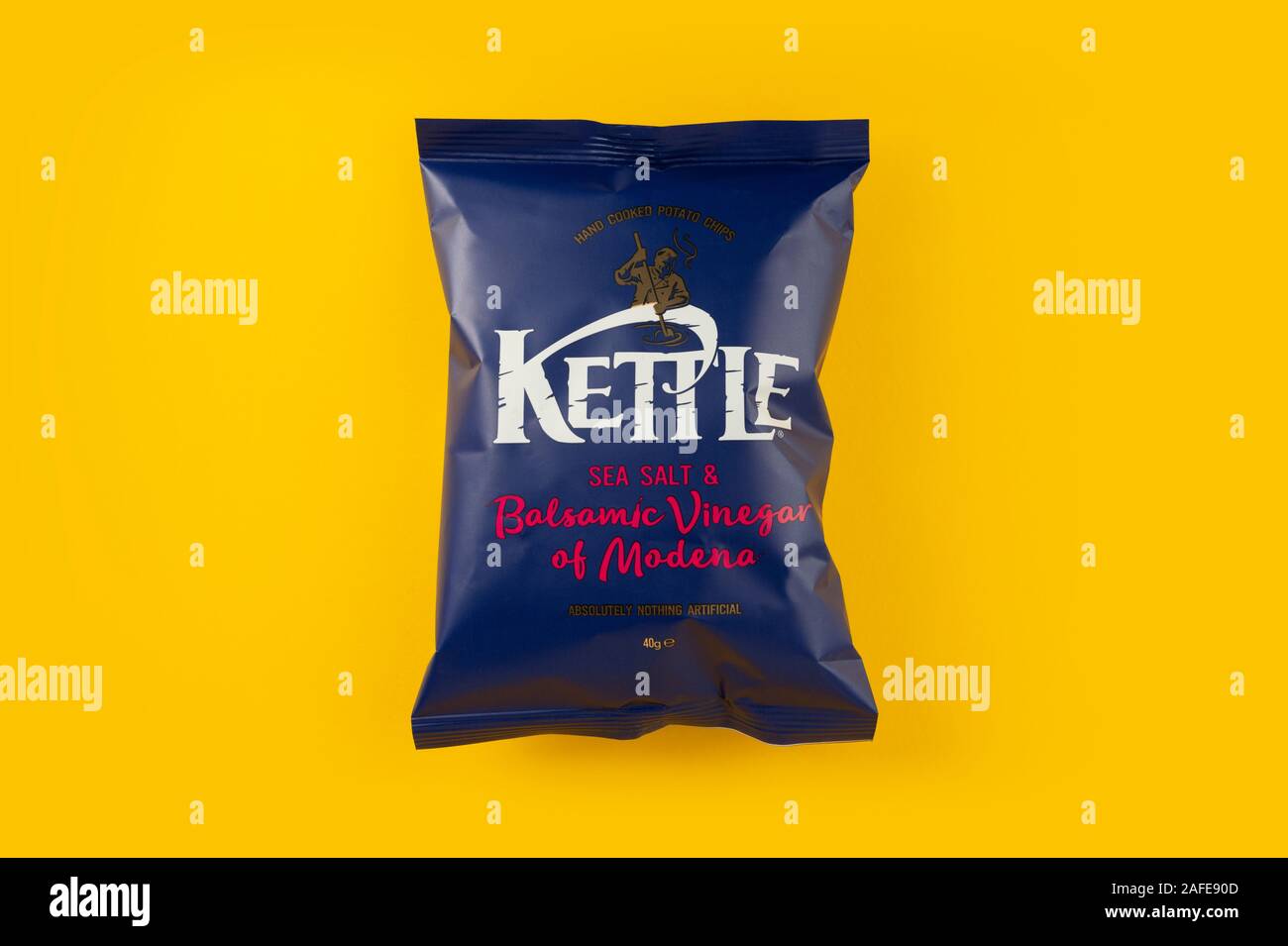 A packet of Kettle sea salt and balsamic vinegar of Modena crisps shot on a yellow background. Stock Photo