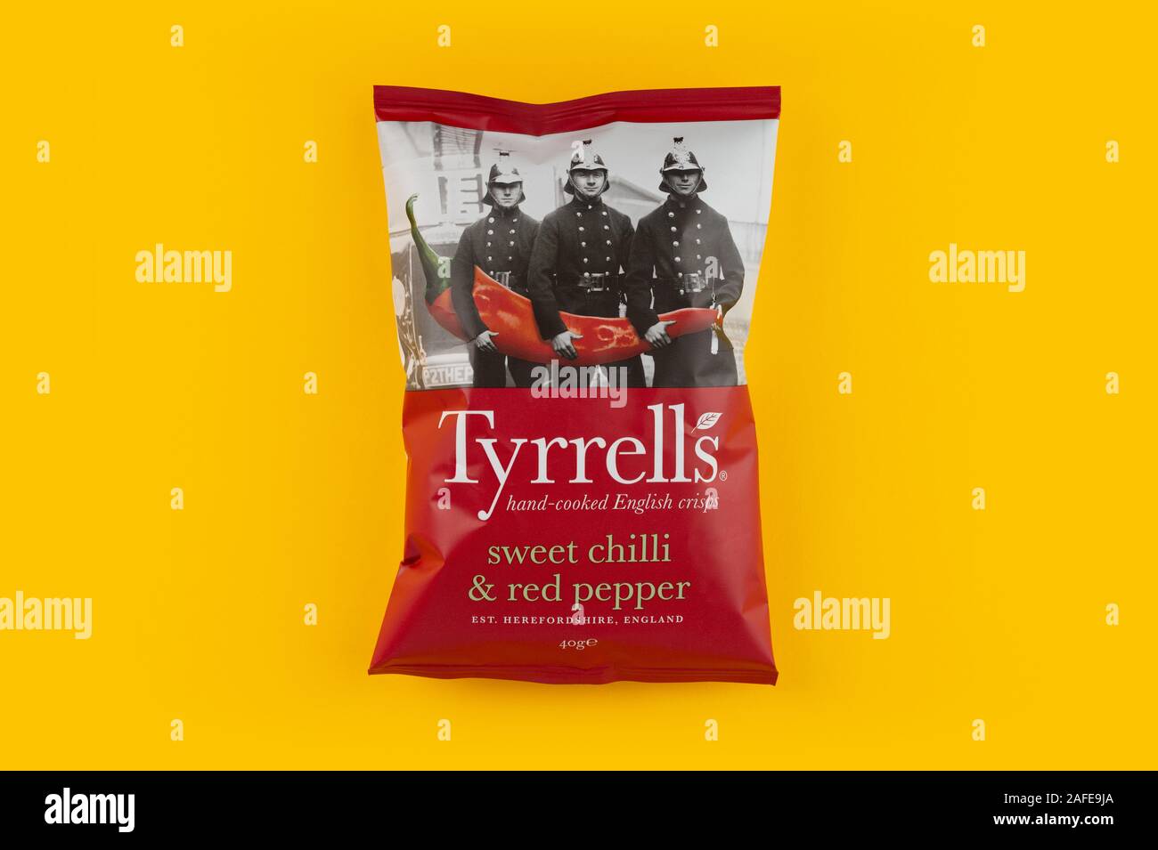 A packet of Tyrrells crisps shot on a yellow background. Stock Photo