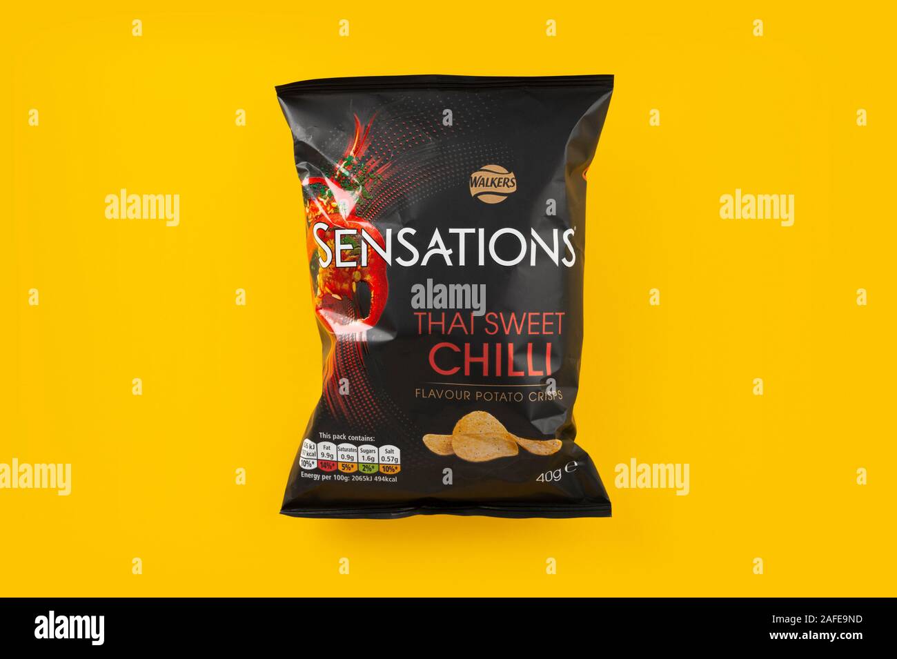 A packet of Walkers Sensations crisps shot on a yellow background. Stock Photo