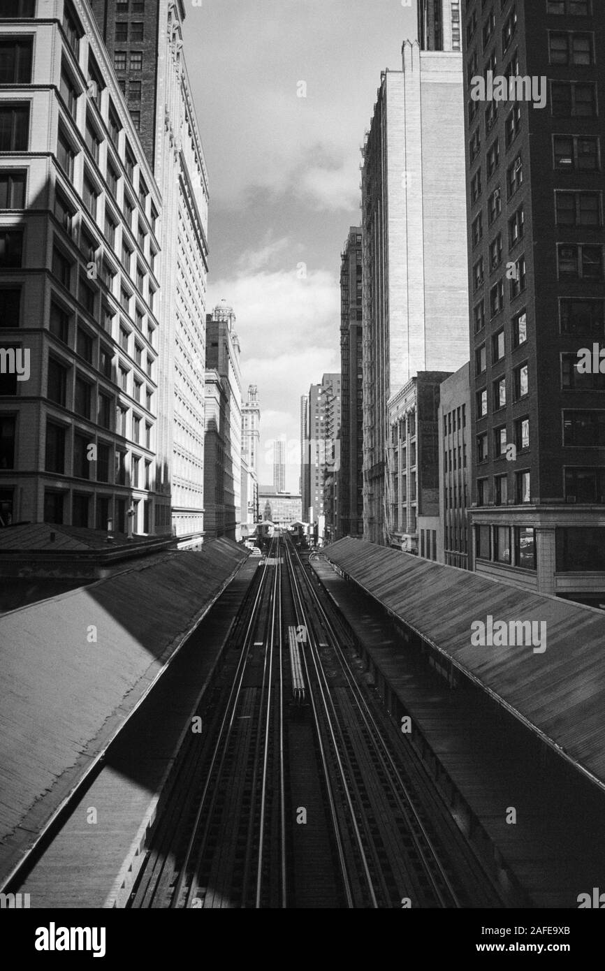 Archival black and white vertical view of downtown architecture and elevated transit train tracks along Wasbash Ave in Chicago Illinois.  Shot with fi Stock Photo