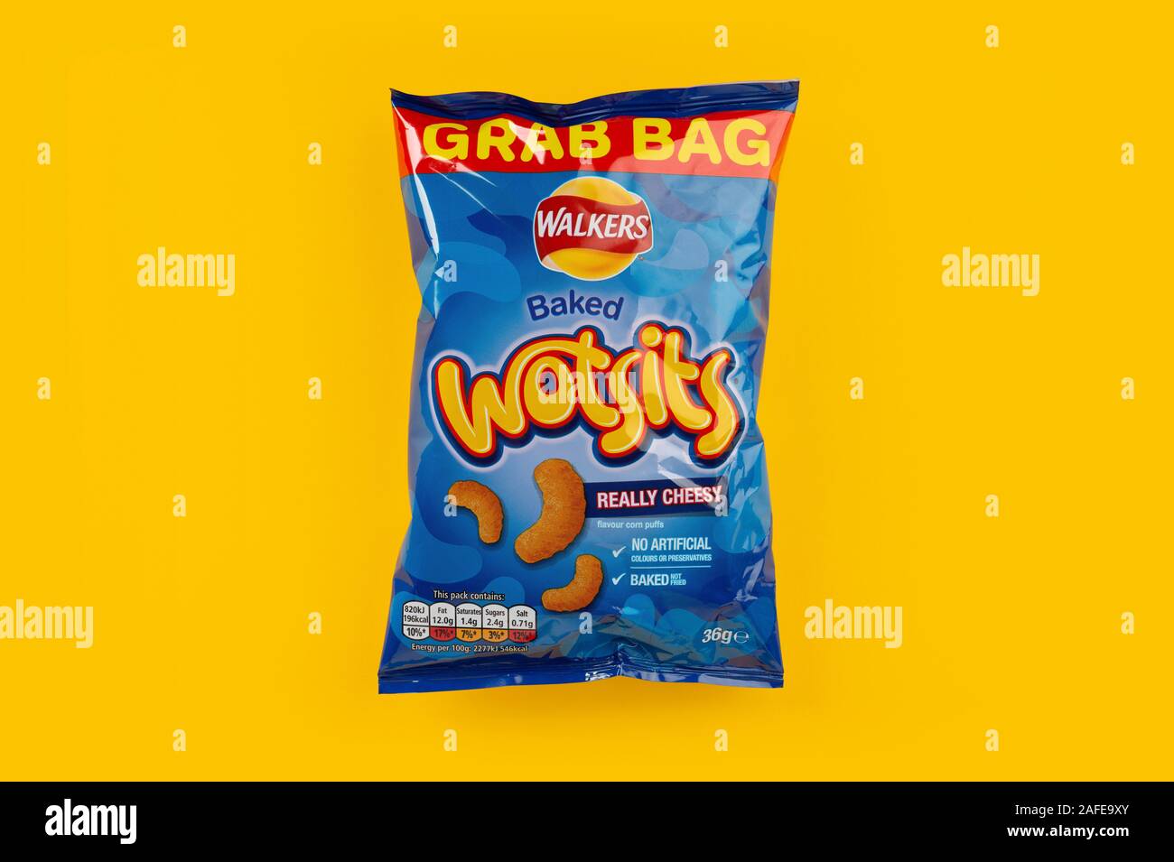 A grab bag packet of Walkers Wotsits crisps shot on a yellow background. Stock Photo