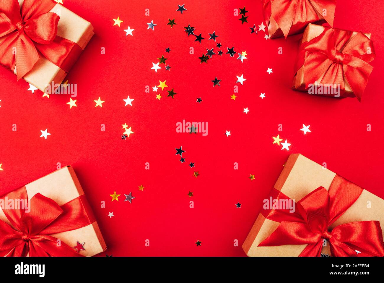 Several gift boxes with bows on a red background. Stock Photo