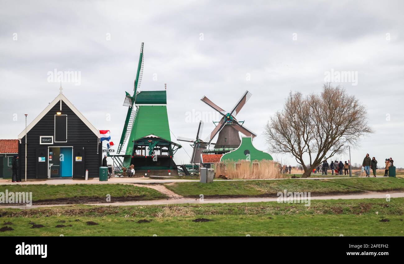 Zaanse Schans, Netherlands - February 25: Tourists walk near old windmills and wooden houses of Zaanse Schans, this town is one of the popular tourist Stock Photo