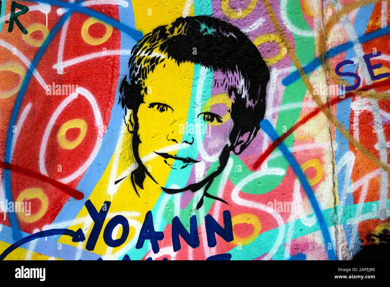 Stencil graffiti on colorful background at East Side Gallery in Berlin, Germany Stock Photo