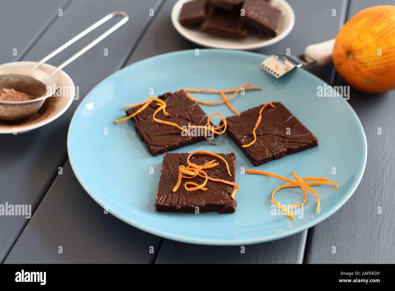 Healthy homemade dark chocolate bars with orange rind on turquoise