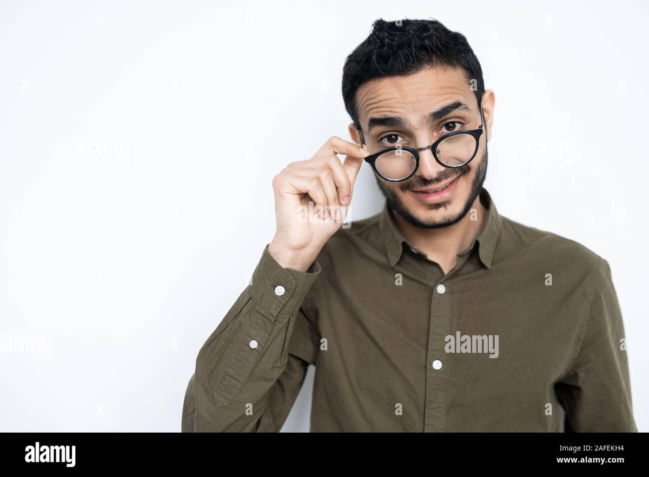 Young man in casualwear taking off his eyeglasses while looking at you Stock Photo