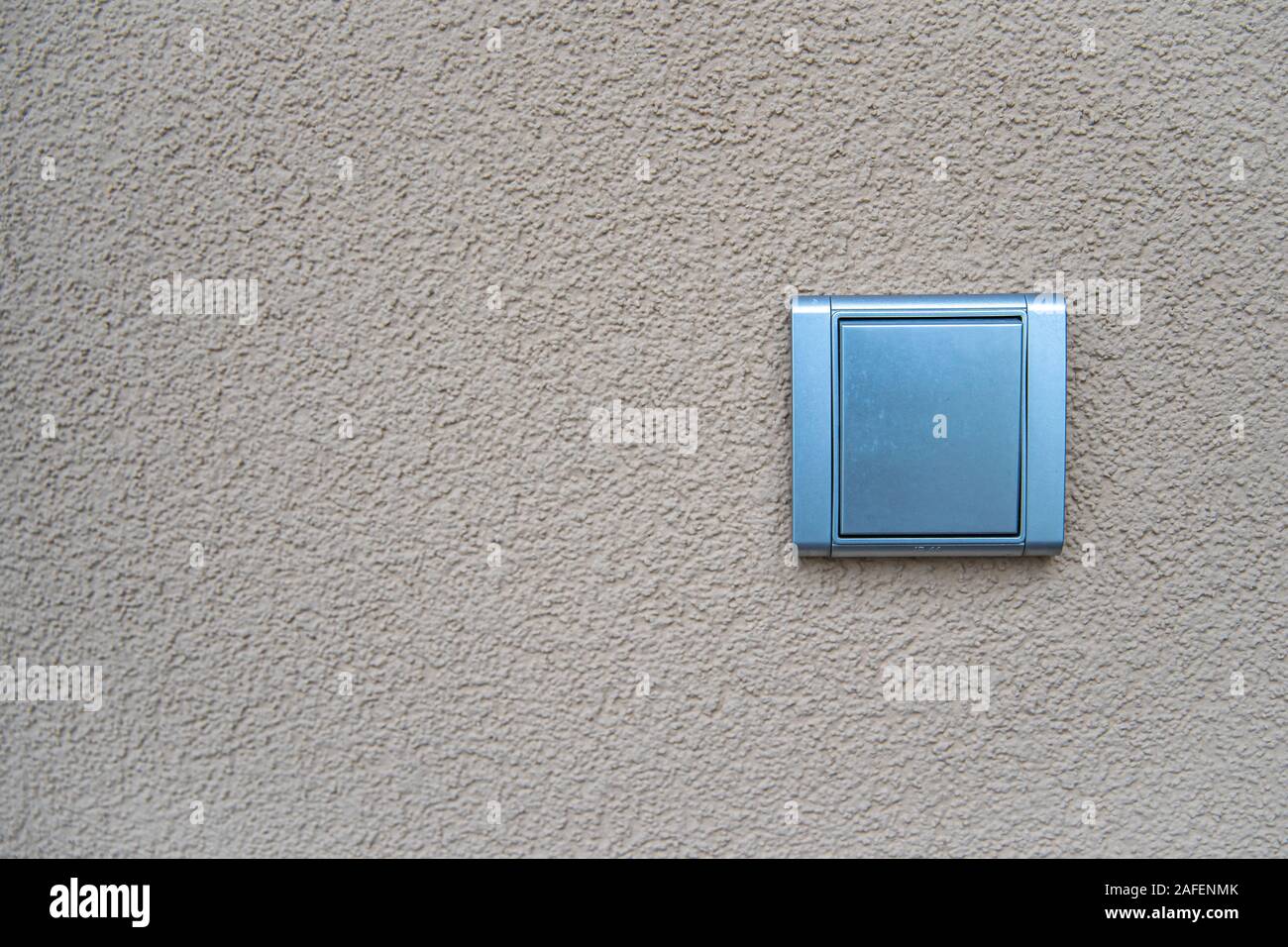 silver light switch on yellow outdoor wall Stock Photo