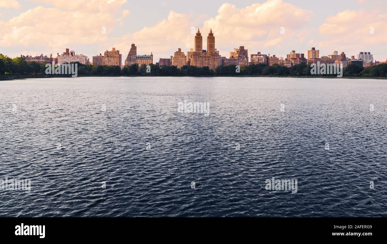 Jacqueline Kennedy Onassis Reservoir lake in Central Park at Sunset. Nyc skyline at background. Travel and City concept. New York City. United States. Stock Photo