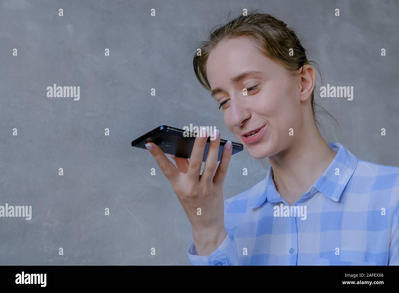 Woman holding smartphone and using voice recognition function Stock Photo