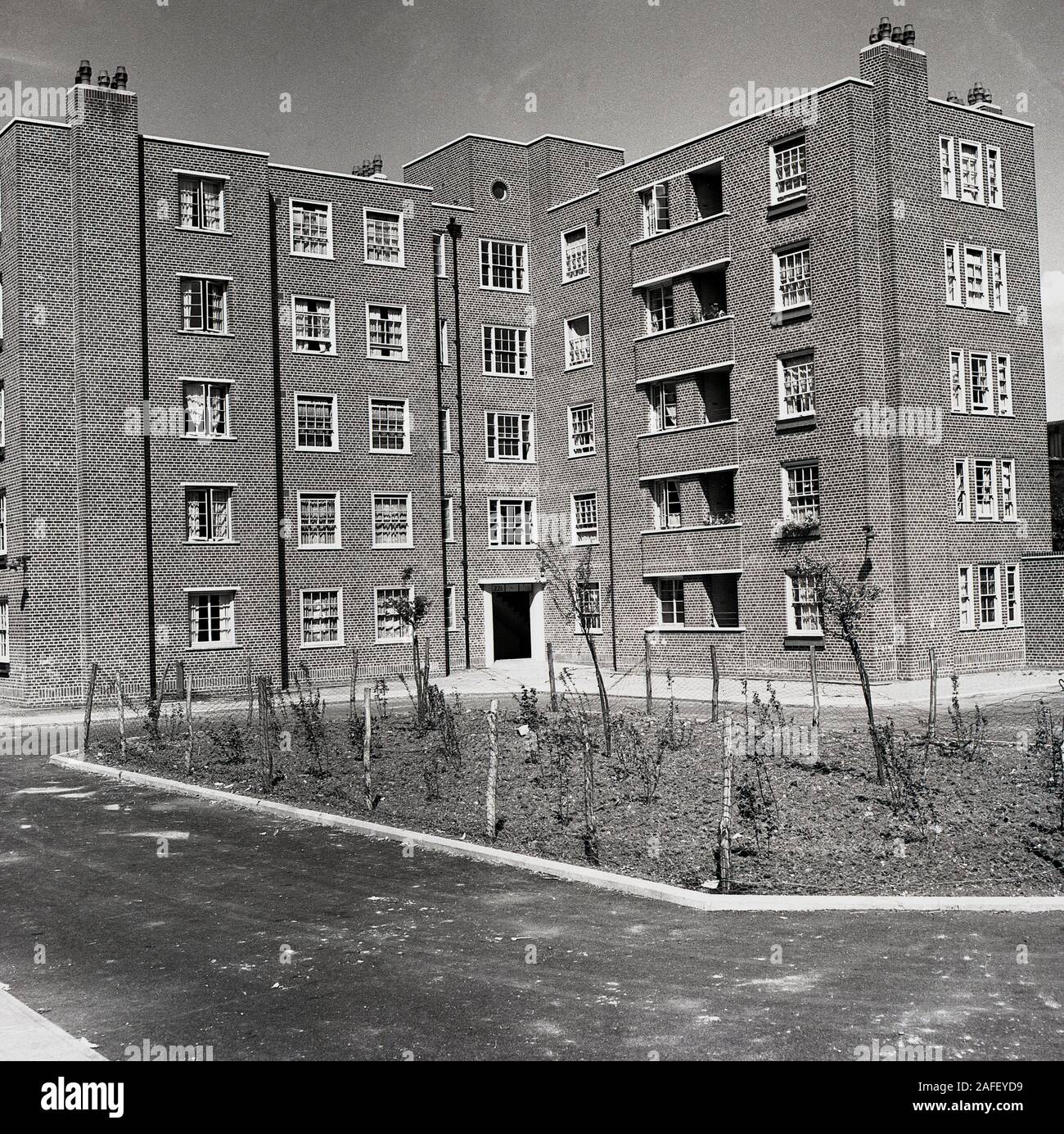1950s, historical, post-war and newly constructed, brick-built blocks of flats or maisonettes, London, England, UK. Built by local authorities to house local workers, these relatively low-level units were built using traditional methods of construction, and were typical of the architectural style of the immediate post-war years, before the high-rise pre-cast concrete built tower blocks of the 'modern' movement of the following decade. Stock Photo
