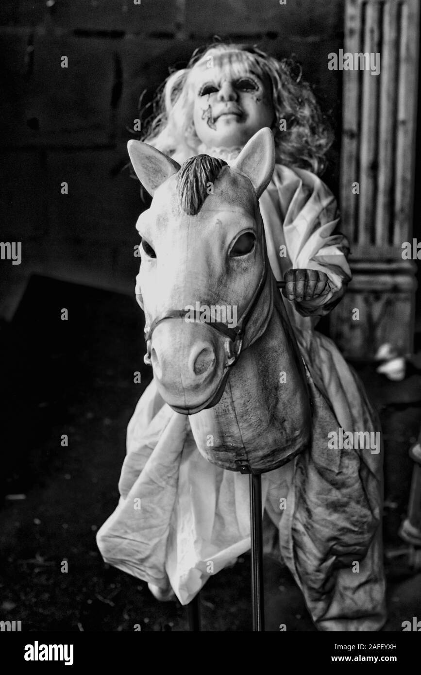 Haunted doll on a body less horse in black and white Stock Photo